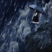 Mädchen mit Schirm steht an Klippe